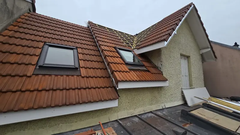Couverture en cours – Toiture en tuiles mécaniques presque terminée, pan central encore en liteaux, Châtillon (92)