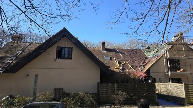 Maison en lisière de forêt dont la toiture est en partie déposée, échafaudage en place, Chevreuse (78)