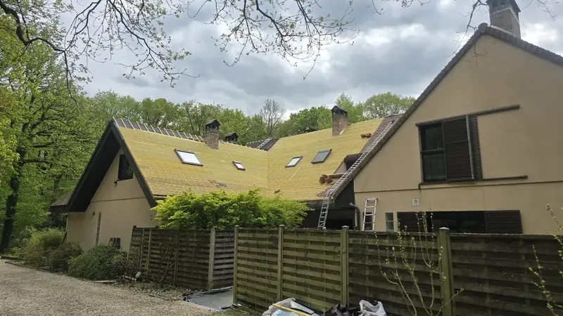 Vue d'ensemble de la maison dont la toiture est couverte de liteaux neufs avant la pose des tuiles, Chevreuse (78)