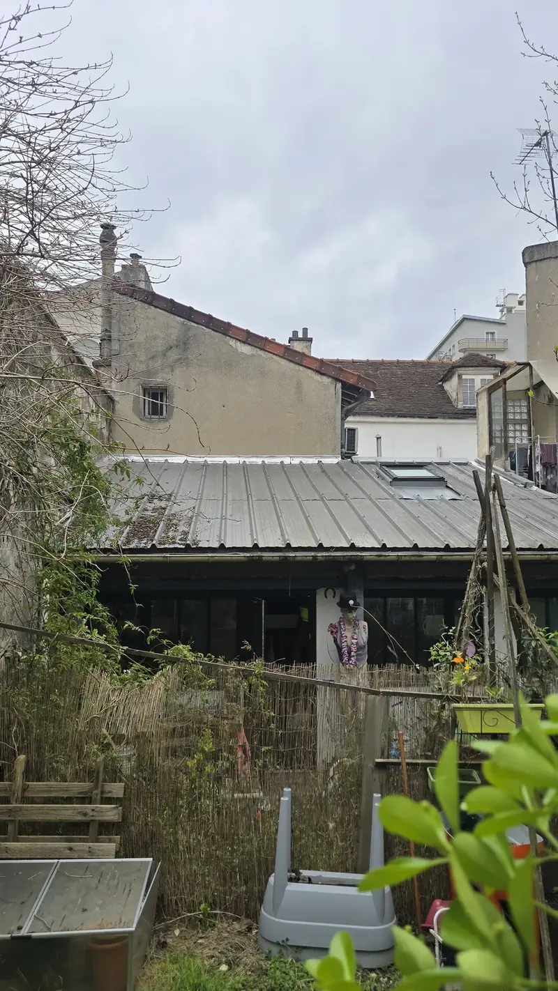 Avant : toit en bac acier – Ancienne toiture en bac acier entre deux murs, vue depuis le jardin avant travaux