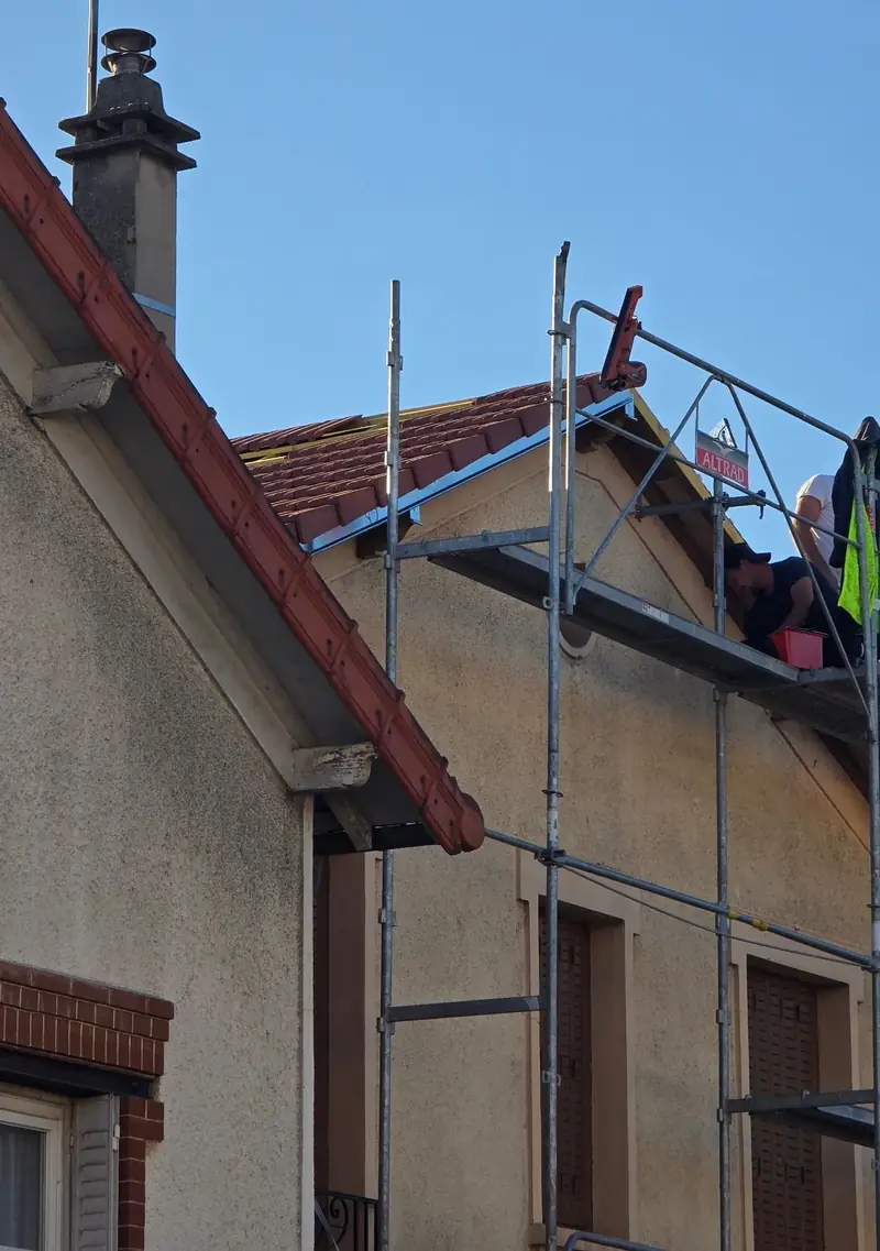 Réfection sous échafaudage – Échafaudage côté rue et couvreurs sur la toiture pendant la réfection d'un pavillon
