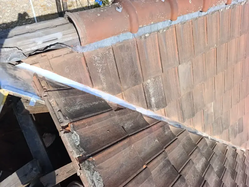 Noue en cours de reprise, couverture ouverte sur le support à la jonction de deux toitures, Choisy-le-Roi (94)