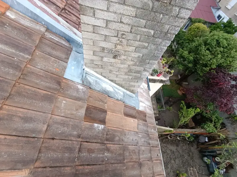 Abergement en zinc neuf au pied d'une souche de cheminée en brique, vue plongeante sur les jardins, Choisy-le-Roi (94)