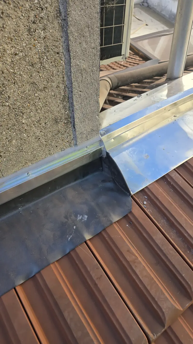 Relevé zinc et solin – Zinc relevé contre un mur et recouvert d'un solin, au-dessus des tuiles PV13, Choisy-le-Roi (94)