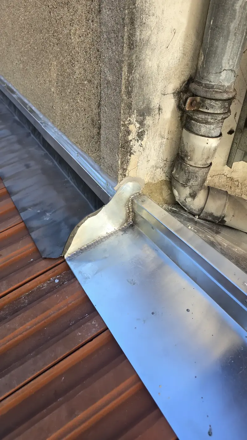 Zinc soudé autour de la descente – Pièce de zinc façonnée et soudée autour d'une descente d'eaux pluviales