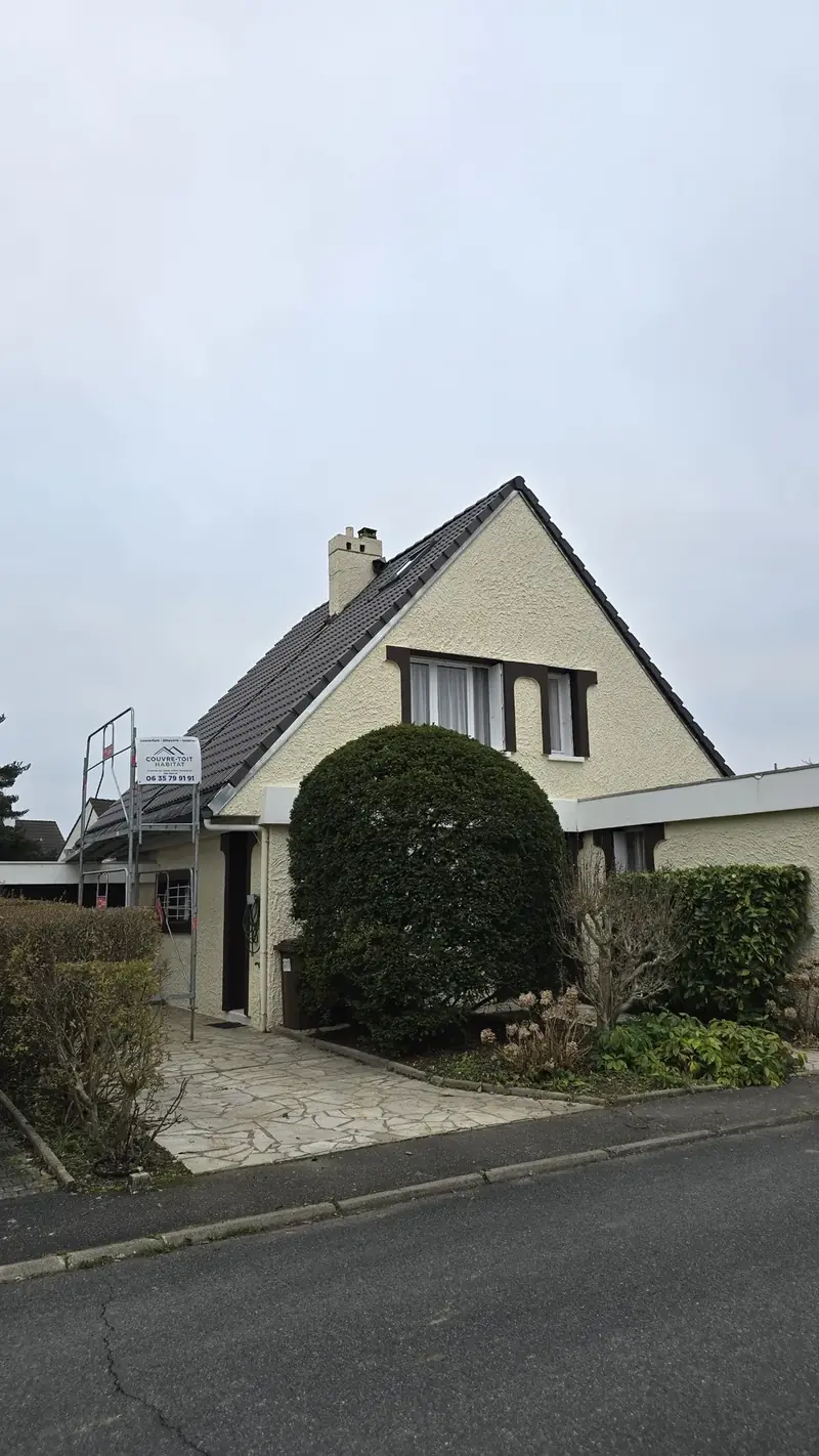 Pavillon et panneau de chantier Couvre-Toit Habitat devant l'échafaudage, toiture en tuiles béton foncées, Évry (91)