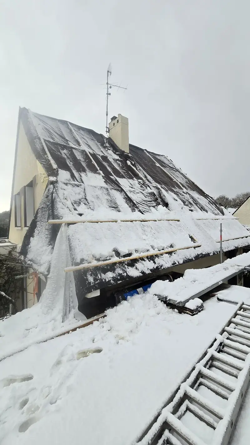 Toiture ouverte protégée par une bâche et l'écran de sous-toiture, recouverte de neige