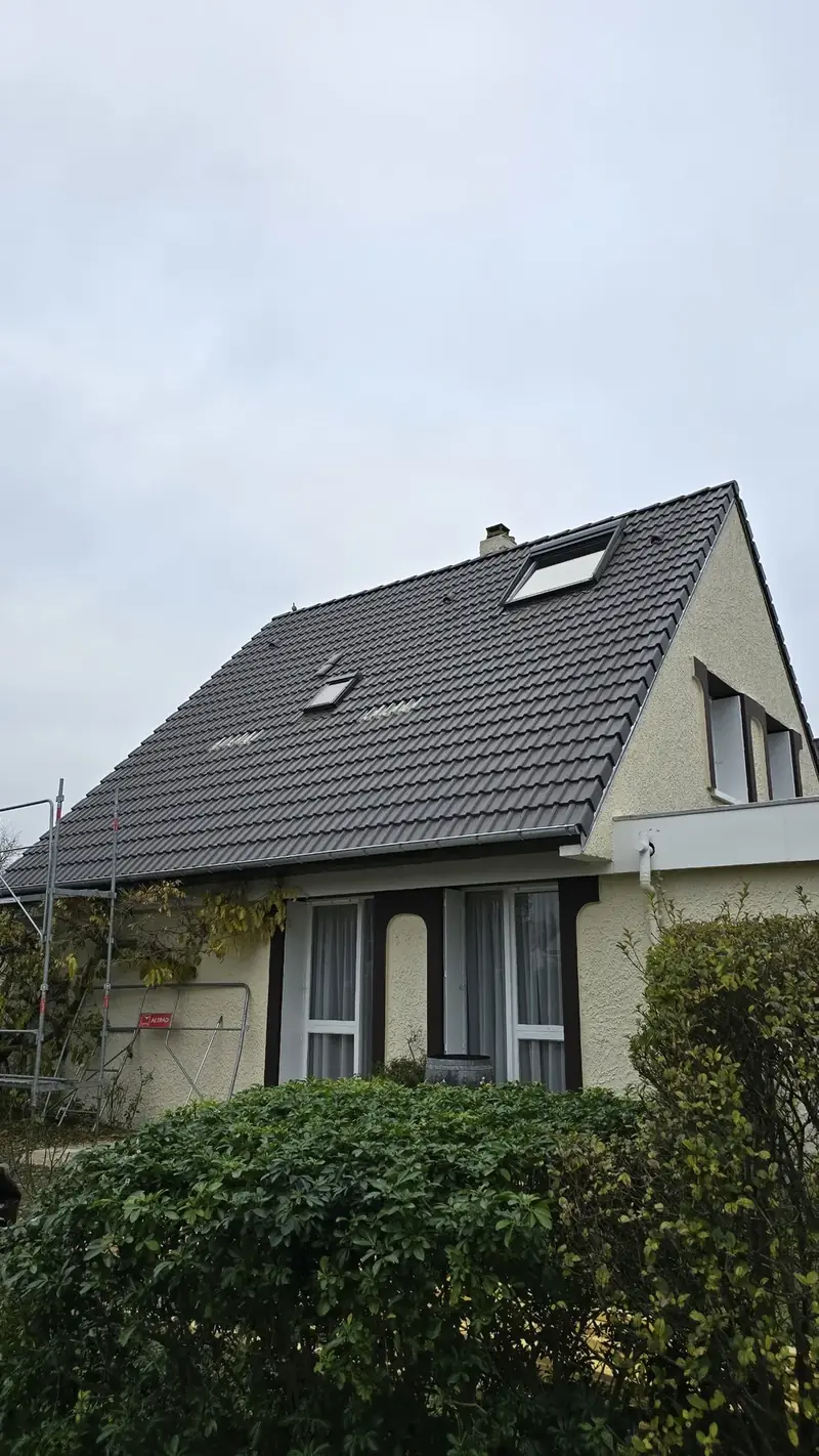 Pavillon à la toiture en tuiles béton foncées avec fenêtres de toit à Évry (91)