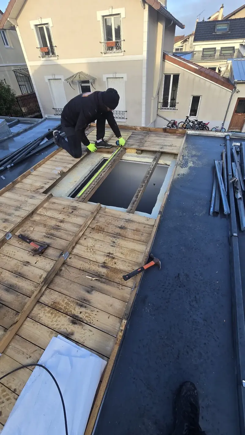 Ouverture pour fenêtre de toit – Couvreur qui mesure l'ouverture dans le voligeage avant la pose de la fenêtre de toit