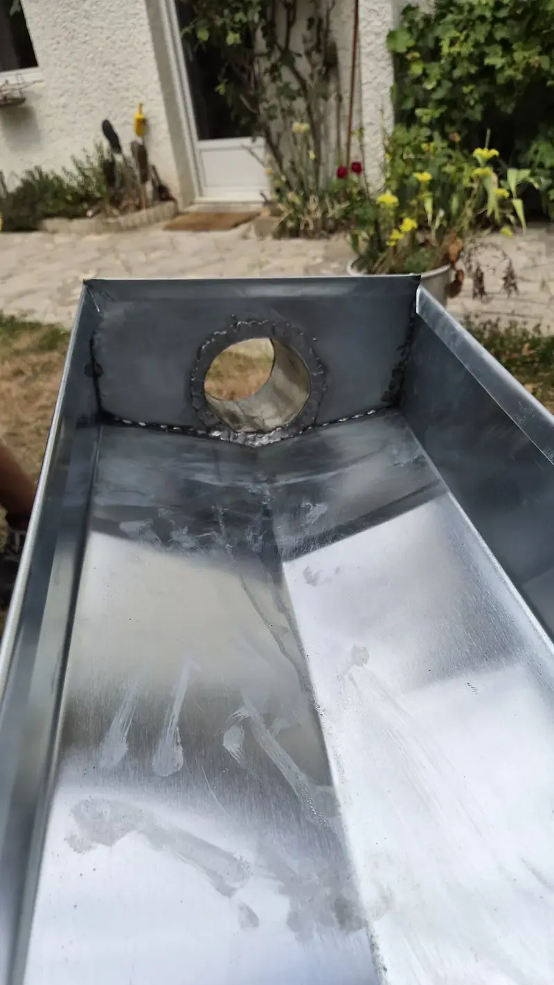 Naissance de descente soudée – Intérieur d'un chéneau en zinc avec une naissance de descente soudée
