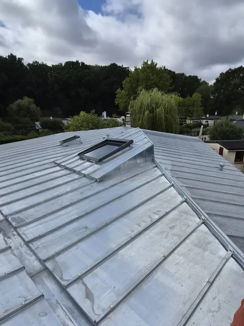 Toiture en zinc naturel à tasseaux terminée, avec sa fenêtre de toit habillée en zinc, Villiers-le-Bâcle (91)